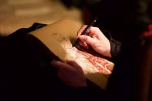 The artist's hand draws a woman during an event in Venice, Italy.